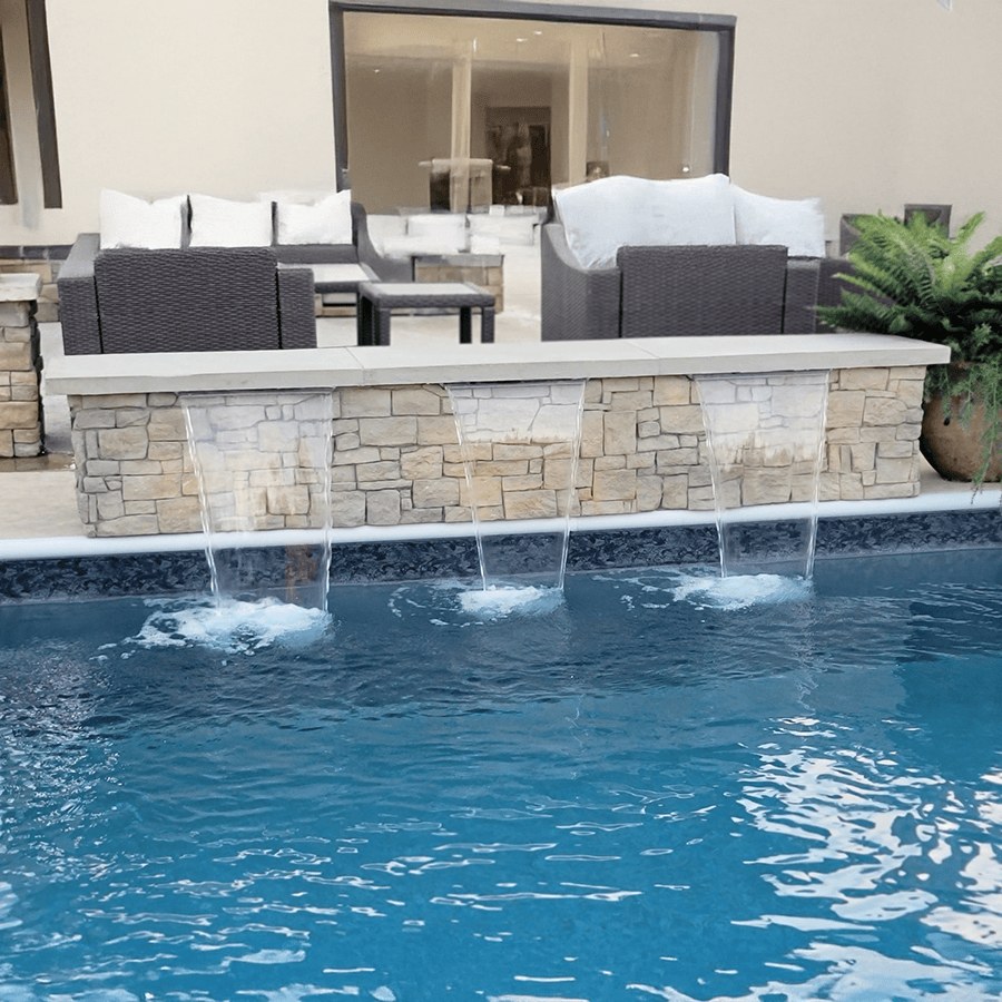 Custom stone water wall with sheer descent waterfalls over a pool